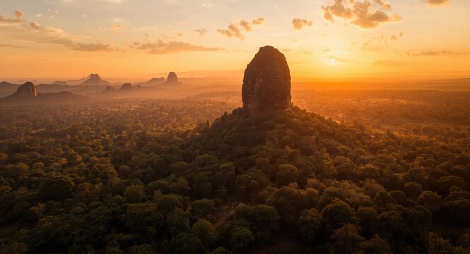 Majestic Mountain Silhouette Surrounded by Lush Forest at Sunset