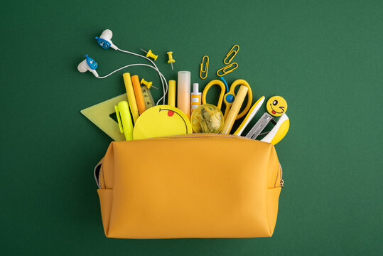 Yellow pencil case opening with school supplies