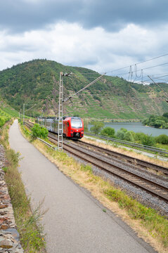 Regional train driving through Moselle valley in Winningen, Germany, railway tracks, modern public transportation, infrastructure in Europe