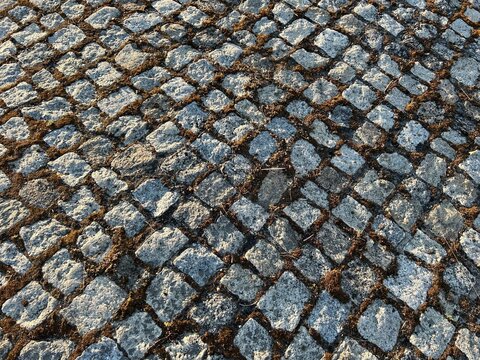 Perspective sur une rue pav&eacute;e mettant en valeur l'alignement des pierres naturelles