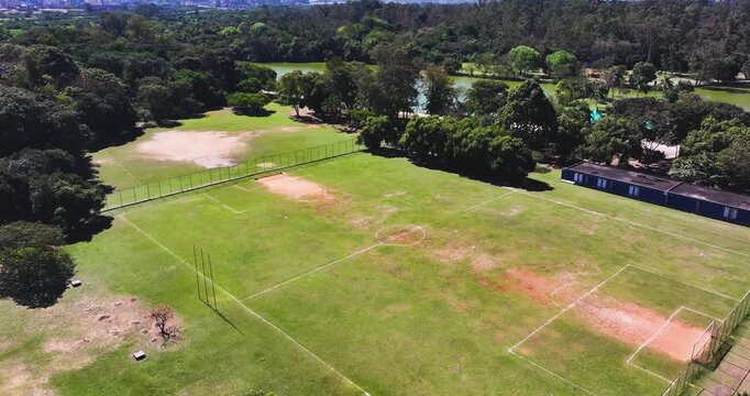 4K aerial drone footage of soccer fields at Parque Ecol&oacute;gico do Tiet&ecirc; in S&atilde;o Paulo, Brazil, surrounded by native forest and green recreation areas.
