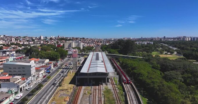 4K aerial drone footage of a train station beside Parque Ecol&oacute;gico do Tiet&ecirc; in S&atilde;o Paulo, Brazil, with urban skyline and railway infrastructure.