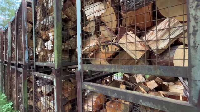 Large Stacks of Split Firewood Stored in Metal Storage Cages