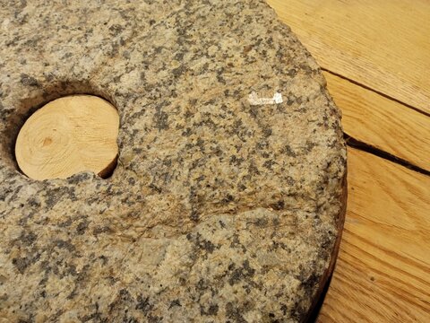 Large stone millstone with a wooden insert on a heated floor