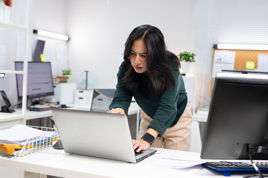 Young businesswoman working on laptop in modern office. Professional using computer for project planning, business management, and workplace productivity.