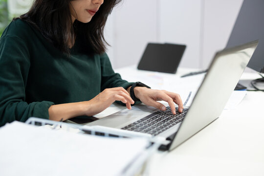 Young businesswoman working on laptop in modern office. Professional using computer for project planning, business management, and workplace productivity.