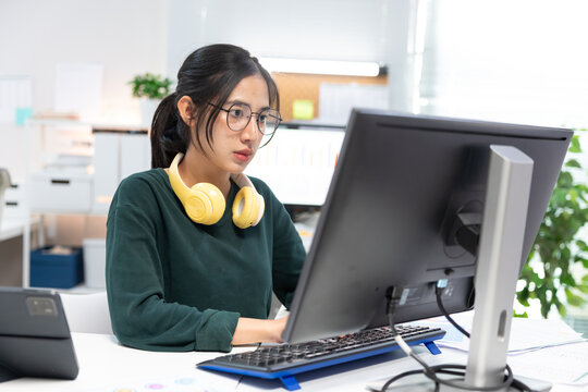 Young businesswoman working on laptop in modern office. Professional using computer for project planning, business management, and workplace productivity.