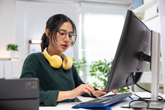 Young businesswoman working on laptop in modern office. Professional using computer for project planning, business management, and workplace productivity.