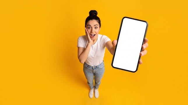 Happy young woman holding mobile phone in hand showing cellphone display. for template mock up
