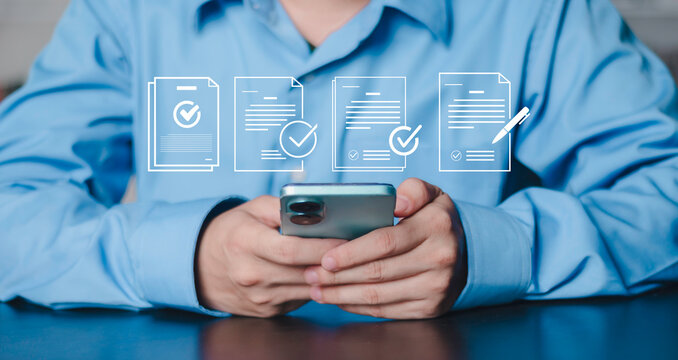 Concept of digital signature, audit, online contract approval, mobile business management and financial tech compliance Businessman hands holding smartphone with floating verified document icons.