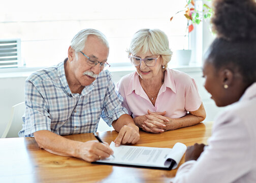 Happy senior old family couple clients make financial insurance estate business deal contract signing, agent lawyer, satisfied mature customers signing contract meeting bank manager agree on investmen