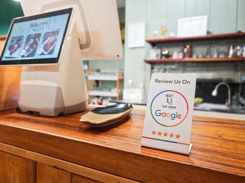 Bangkok, Thailand - 23 July 2026; A review tag with NFC technology inside, using smartphone to tap for review this restaurant on Google. New technology for business working is presented.
