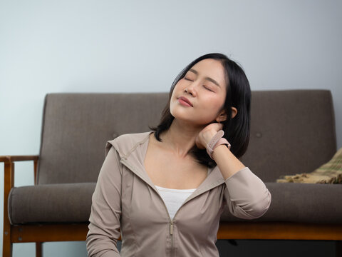 Asian woman touching her neck feeling pain after home exercise