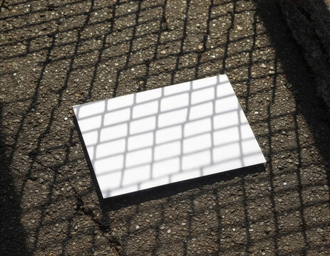 Blank white flyer mockup template on asphalt with grid shadow