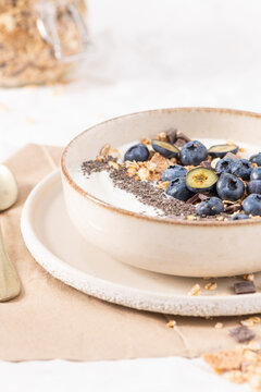 Healthy breakfast bowl with fresh blueberries granola and chia seeds in a rustic ceramic dish for a nutritious and delicious morning meal