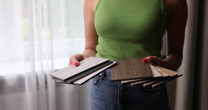 Woman choosing materials from wood samples for flooring and furniture. Interior design and renovation