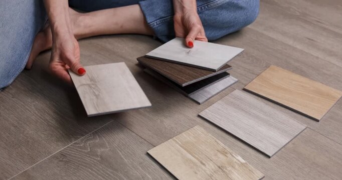 Woman choosing wood flooring samples for home renovation and interior design