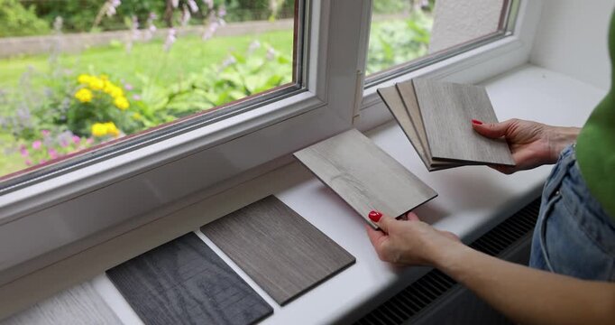 Woman choosing materials from wood samples for flooring and furniture. Interior design and renovation