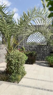 Serene courtyard with stone arches and palm trees at historic Masjid Bani Anif, Madinah.
