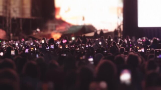 Audience filming concert with mobile phones during summer music festival
