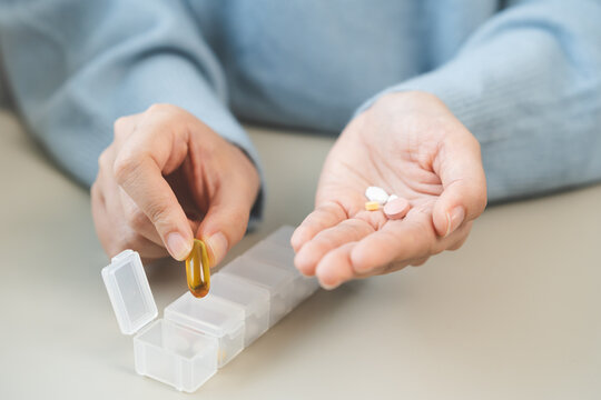 Sick, illness asian young woman, girl holding vitamins fish oil, pills preparing to put in pill box for medication to take daily, pain for treatment, take drug or vitamin, health care person concept.