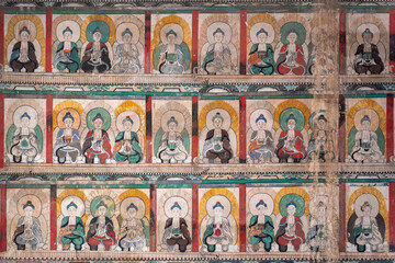 Ancient Buddhist wall mural in Zhenguo Temple, Pingyao, Shanxi, China, rows of seated Buddha figures © 煜炜 刘