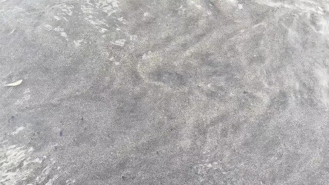 Clear shallow water ripples over sandy seabed background