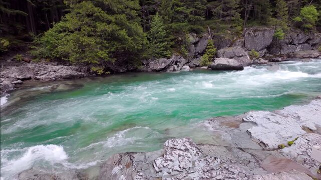 View of the turquoise glacial water of McDonald Creek in Glacier National Park, Montana.