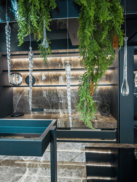 Contemporary interior with marble texture, glowing lights, green foliage and suspended glass icicles