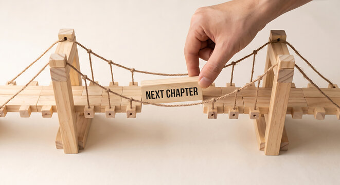 Hand building a wooden bridge labeled with next chapter text. Next Chapter text concept.
