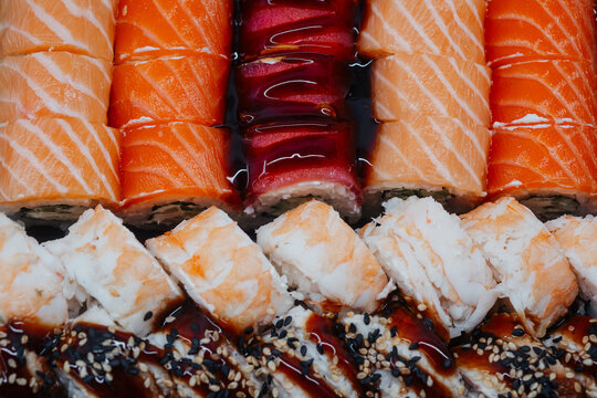 Assortment of sushi rolls with salmon and shrimp on a dark background