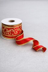 Fototapeta premium Two rolls of red and gold ribbon, possibly for gift wrapping or crafting