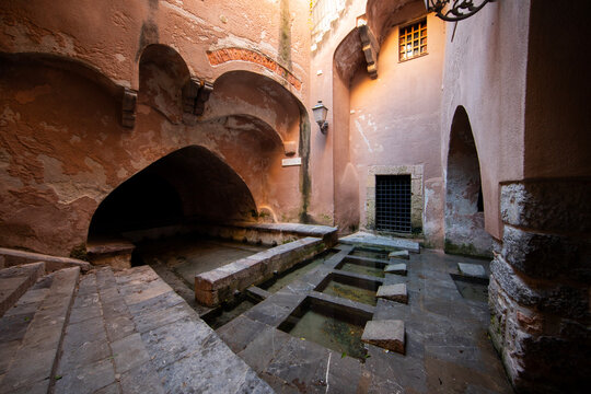 Lavatoio Medievale in Cefalu, Sicily, Italy. Ancient public wash house with stone basins and arches in the old town of the city.