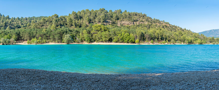 Sainte-Croix-du-Verdon, France - 07 05 2026: Panoramic view of the Lake Sainte-Croix, beach, hills and forests in sunny blue sky