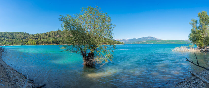 Sainte-Croix-du-Verdon, France - 07 05 2026: Panoramic view of the Lake Sainte-Croix, beach, hills and forests in sunny blue sky