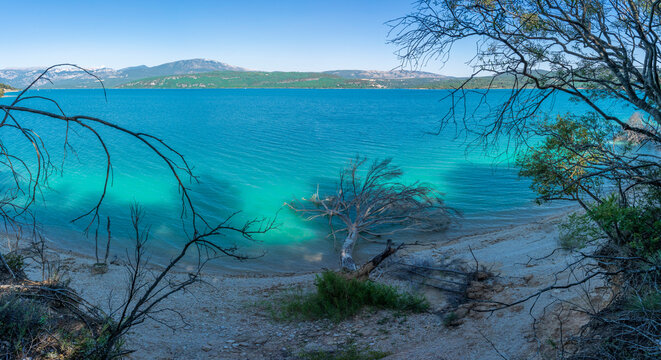 Sainte-Croix-du-Verdon, France - 07 05 2026: Panoramic view of the Lake Sainte-Croix, beach, hills and forests in sunny blue sky