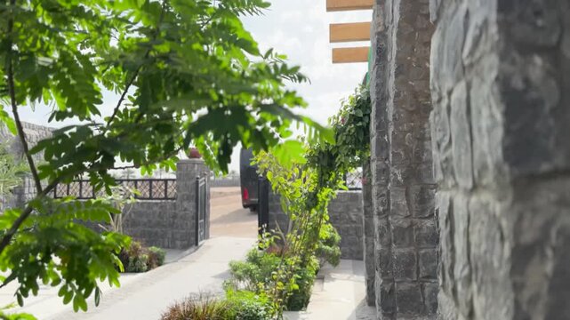 View of the stone arch entrance at historic Masjid Bani Anif framed by green leaves.