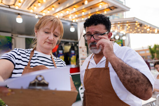 Small business partners reviewing documents at food stand