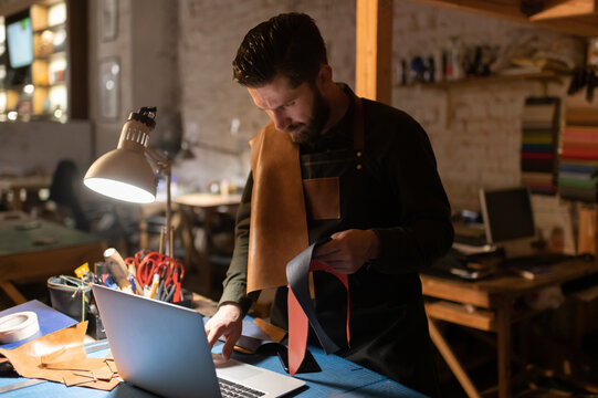 Serious man with leather browsing laptop