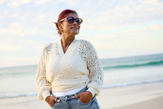 Woman Standing on Beach Smiling at Sunset