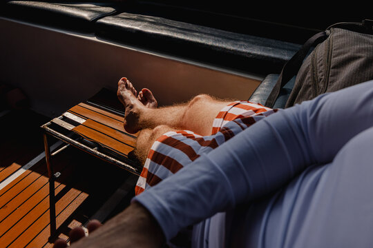 Man relaxes on the boat deck while wearing swimwear