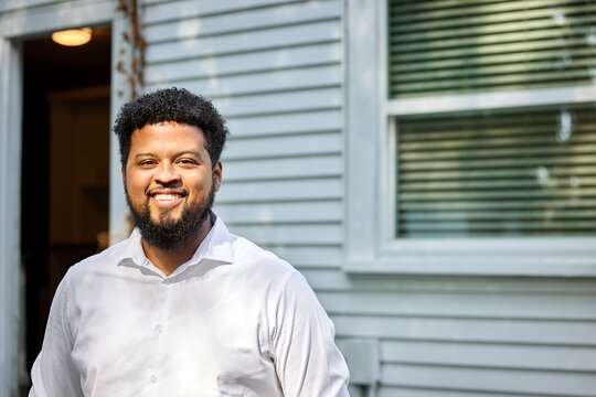 Man Smiles Outside House During Afternoon