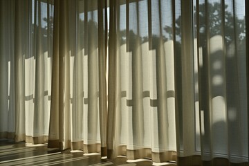 Obraz premium Bright morning sun shines through soft white window curtains inside modern room. Transparent fabric drapes cast long shadows on floor. Light filters behind translucent drapery creating peaceful home