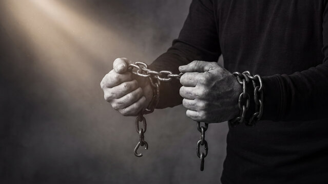 Man with chained hands symbolizing imprisonment captivity and loss of freedom or human rights