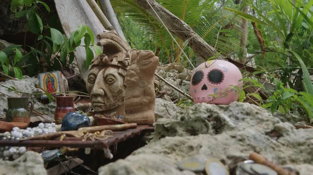 Indigenous mayan offering with a clay sculpture and a pink sugar skull in a jungle setting