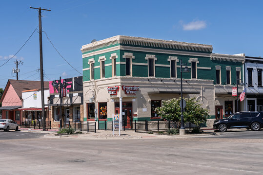 Killeen, TX - 10 July 2026: A view of a corner brick building housing Strike Out Wingz on a sunny day in Texas