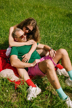 A woman hugs a man on green grass
