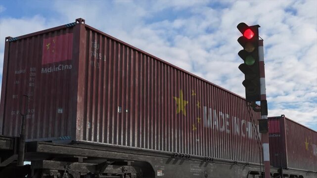 Train transporting Chinese cargo containers stops at red light, tariffs concept