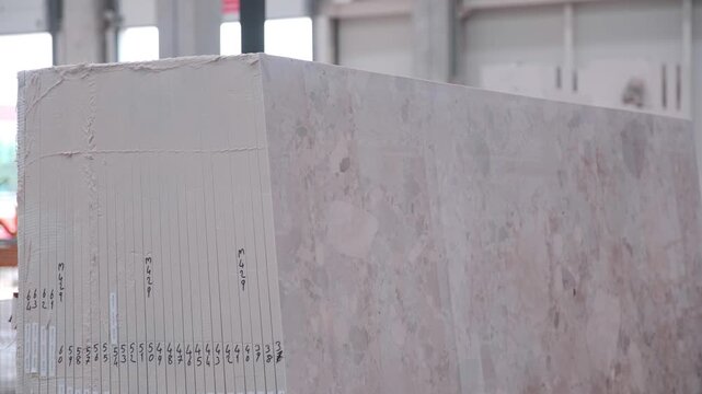 Heavy machinery cutting large marble block in natural stone factory production line
