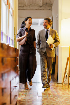 Businesspeople walking hallway discussing business